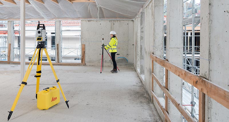 Construction worker in yellow high visibility jacket and hard hat laying out a point with the iCON iCR70.