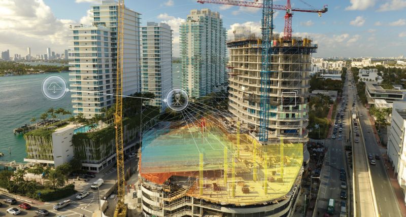 Leica iCON CC80 field controller with iCON build software with point layout and building construction project on the background.