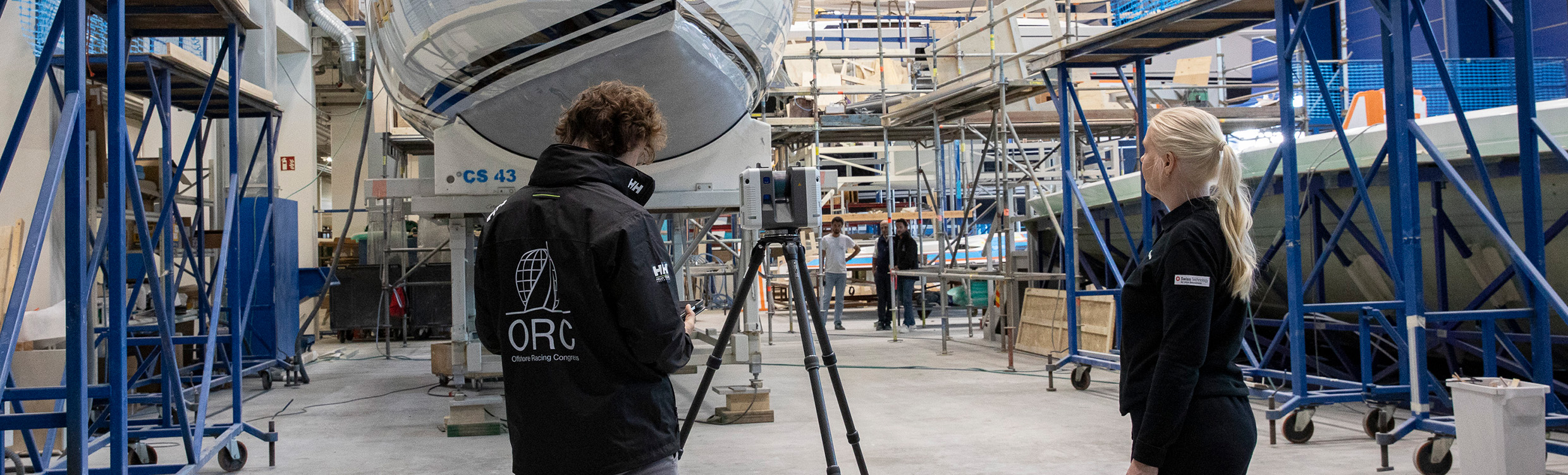 En representant från Offshore Racing Congress scannar skrovet på en yacht med en laserscanner